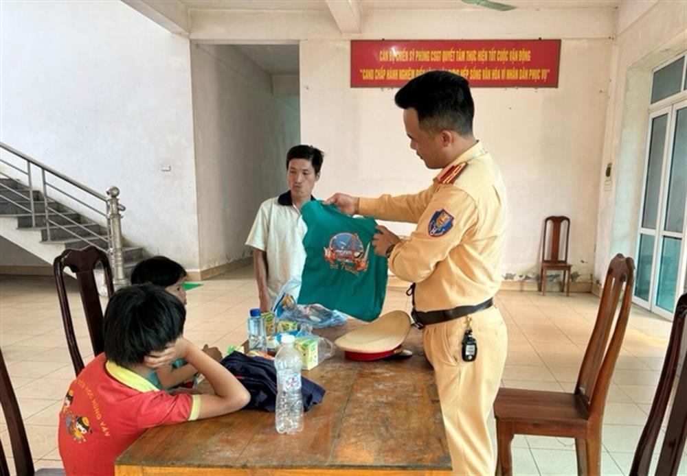Cán bộ Cảnh sát giao thông trao bộ quần áo mới tặng hai cháu.