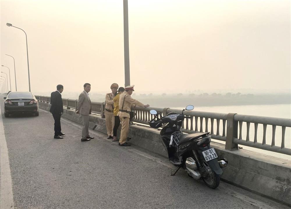 Lực lượng Cảnh sát giao thông Công an tỉnh cùng người dân động viên người phụ nữ từ bỏ ý định tự tử.