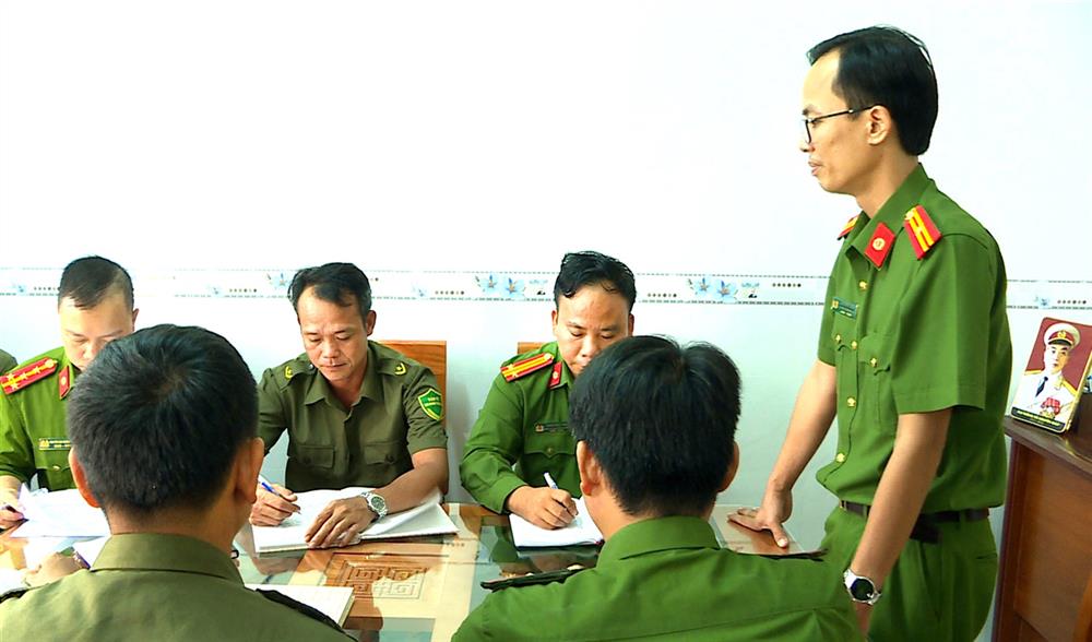 Thiếu tá Nguyễn Vũ Long họp bàn và lực lượng tham gia bảo vệ ANTT ở cơ sở triển khai nhiệm vụ phòng chống tội phạm.