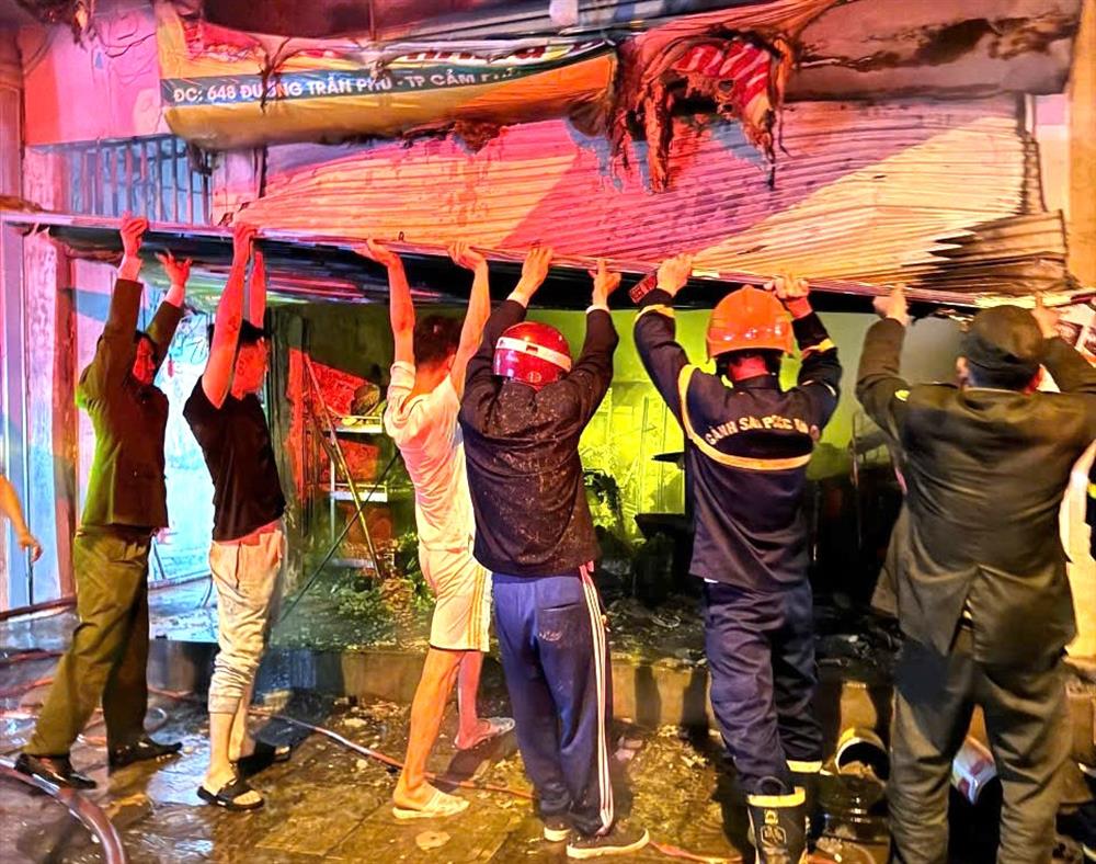 Các lực lượng phá dỡ cửa cuốn để tiếp cận người bị nạn.