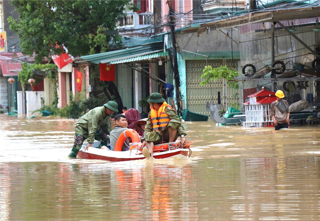 Cán bộ Công an huyện đưa người dân ra khỏi vùng lũ đi chạy thận nhân tạo.