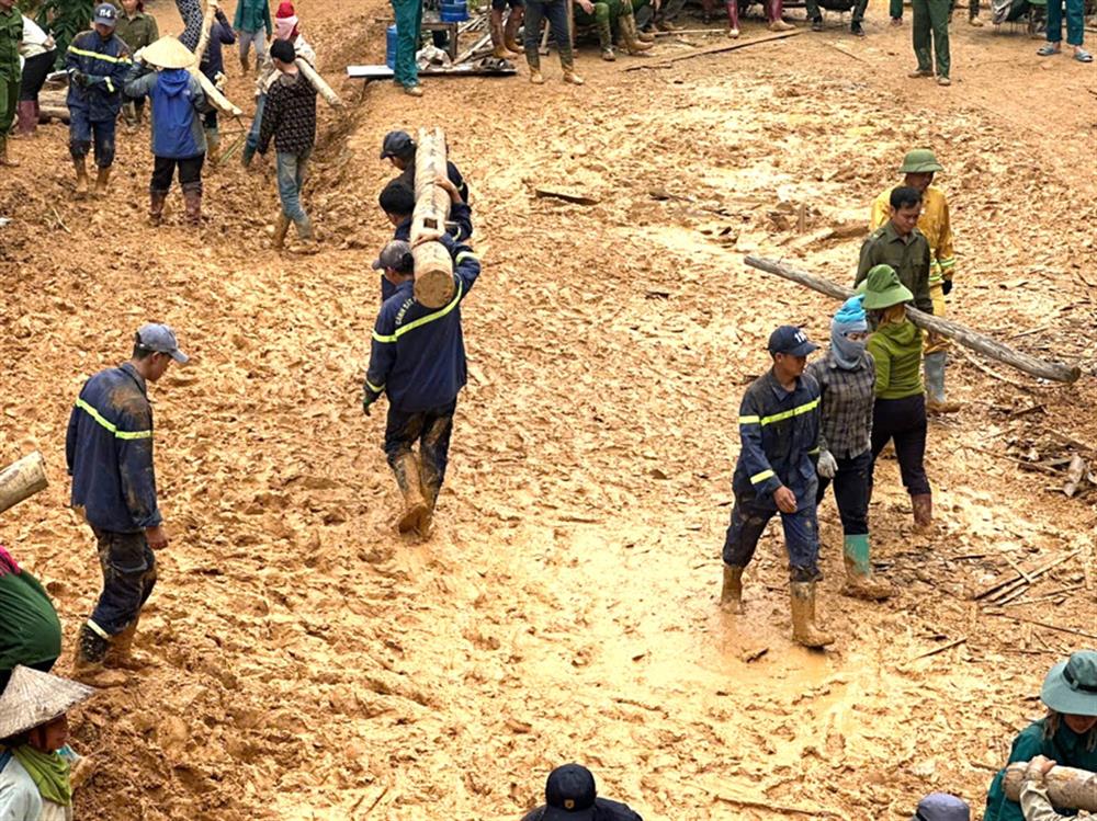 Các cán bộ, chiến sĩ Công an miệt mài hỗ trợ người dân trong mưa.