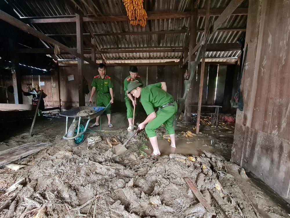 Công an huyện Than Uyên giúp dân xúc bỏ bùn đất tràn vào nhà tại bản Hô Ta, xã Tà Mung.