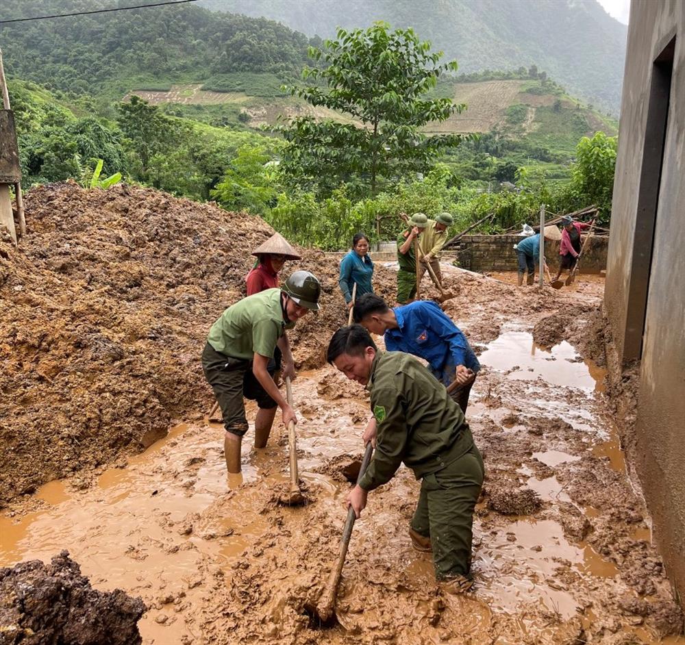 Dọn dẹp lượng lớn bùn đất tràn vào nhà dân sau lũ.