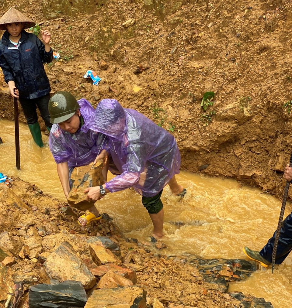 Phối hợp với các lực lượng đào rãnh thoát nước chống vỡ đập tích nước tại bản Xoong, xã Tà Mung.