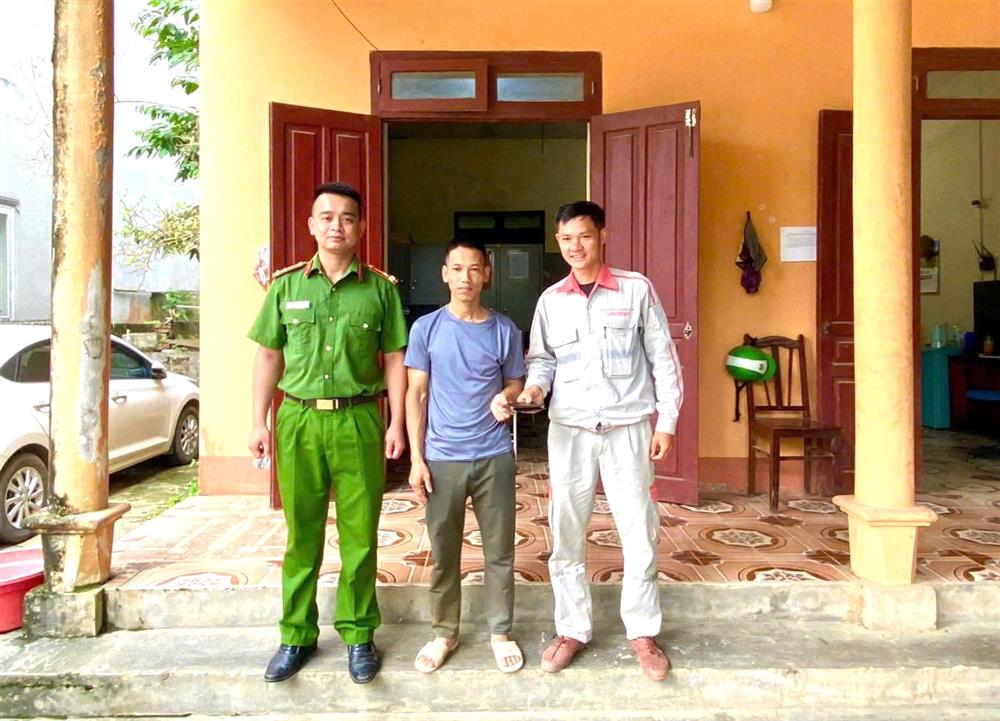 Anh Hoàng Văn Tháo nhận lại tài sản đánh rơi từ Công an xã Hồng Phong và anh Lê Văn Tuấn (bên phải).