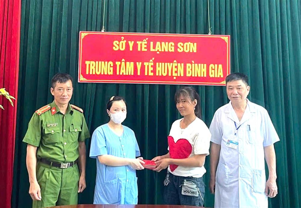 Chị Triệu Thị Tâm (bên phải) nhận lại tài sản đánh rơi từ Công an thị trấn Bình Gia, lãnh đạo Trung tâm y tế huyện và chị Hoàng Thị Hằng.