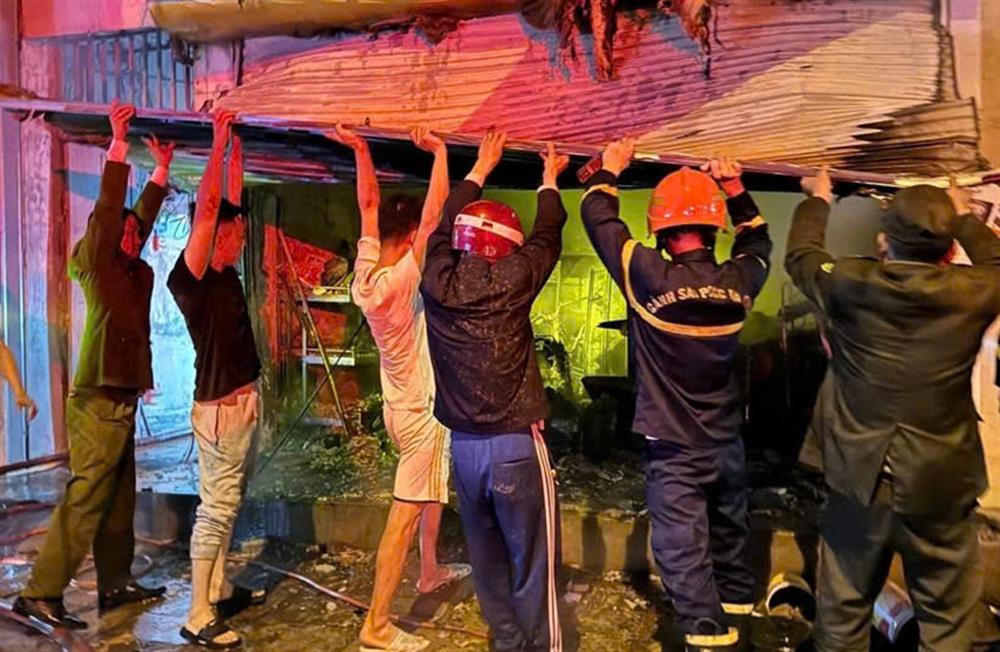 Công an phường Cẩm Thạch phối hợp với các lực lượng phá dỡ cửa cuốn để giải cứu người bị nạn.