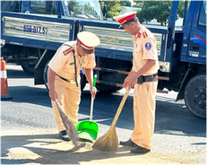 Cảnh sát giao thông Cần Thơ dọn dẹp cát rơi trên đường để đảm bảo an toàn giao thông
