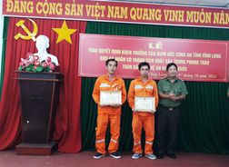 Hai nhân viên điện lực nhận Giấy khen của Giám đốc Công an tỉnh Vĩnh Long